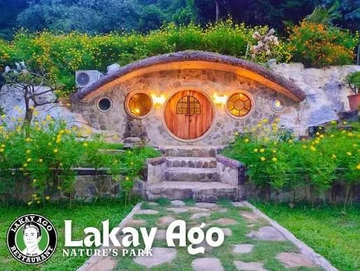 A stone storybook cottage with a round door and flower garden at Lakay Ago Nature's Park in Agoo.