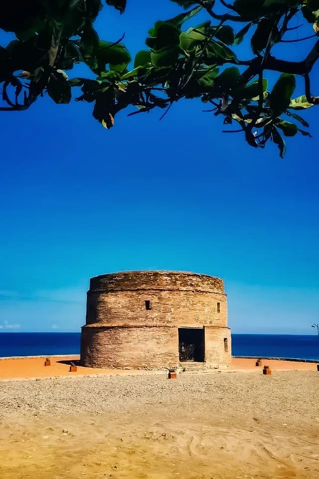 The Spanish-era Baluarte watchtower on Luna's pebble shore.